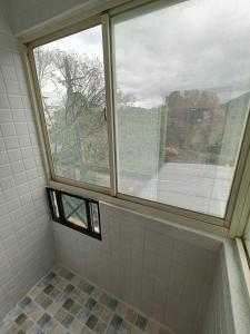 的住宿－龍潭十六石遛民宿 桃園市民宿127號，浴室设有窗户和瓷砖淋浴。