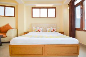 ein Schlafzimmer mit einem großen Bett und einem Sofa in der Unterkunft OYO Home 78009 Avon Villa Kanlog in Shimla