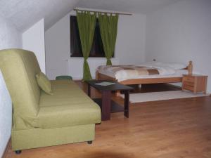a bedroom with a bed and a couch and a chair at Motel Luka in Deževice