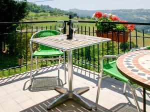 una mesa con 2 sillas verdes y copas de vino en Apartment Livella - MZO100 by Interhome, en Belvedere Langhe