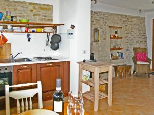 una cocina con mesa y sillas y una botella de vino en Apartment Livella - MZO100 by Interhome, en Belvedere Langhe