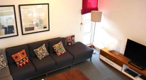 a living room with a couch and a television at So Beach Villa In Situ in Roches Noires