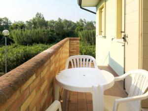 d'une table et de chaises blanches sur un balcon. dans l'établissement Apartment Solmare-8 by Interhome, à Rosapineta
