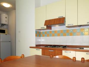 een keuken met witte kasten en een houten tafel bij Apartment Solmare-13 by Interhome in Rosapineta +13 foto's