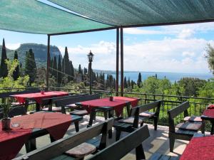 un patio con mesas y sillas y vistas al océano en Apartment Parco del Garda-4 by Interhome, en Garda