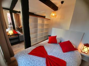 1 dormitorio con 1 cama grande con almohadas rojas en Andra Mari Apartamentu Turistikoak en Bermeo
