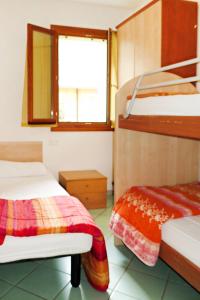 een slaapkamer met twee stapelbedden en een raam bij Apartment Solmare-10 by Interhome in Rosapineta +13 foto's