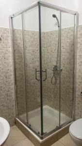 um chuveiro com uma porta de vidro na casa de banho em Hotel Central Santa Maria em Santa Maria