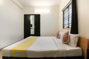 sypialnia z dużym łóżkiem i oknem w obiekcie OYO Home Harma Residency Near Koyambedu Metro Station w mieście Ćennaj