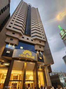 Al Massa Grand Hotel في مكة المكرمة: مبنى كبير فيه ناس واقفه خارجه