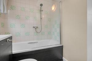 a bathroom with a shower and a tub and a toilet at Edinburgh City Center Coady Apartment SLEEPS 5 FREE CAR PARK SPACE in Edinburgh