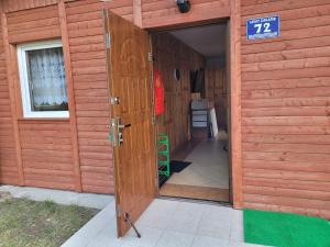 eine offene Tür zu einem Gebäude mit einem Schild darauf in der Unterkunft Domek letniskowy nad jeziorem w Gołdapi, Wczasowa72 in Goldap
