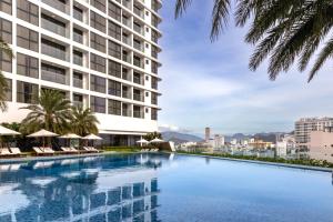 a large swimming pool in front of a tall building at Meliá Vinpearl Nha Trang Empire in Nha Trang