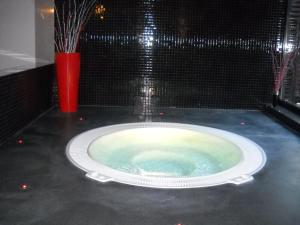 a large bath tub in a room with a red vase at Apartmány Areál Ados in Harrachov