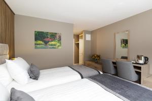 a bedroom with two beds and a desk at Castle Varagh Hotel & Bar in Westmeath