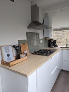 a kitchen with white cabinets and a stove top oven at Cabin Life Durbuy in Durbuy +31 photos