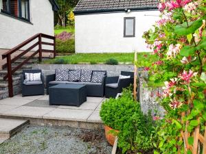 a patio with two couches and a staircase with flowers at Villa Solas by Interhome in Kensaleyre