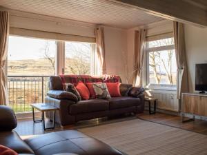 a living room with a couch and a large window at Villa Solas by Interhome in Kensaleyre