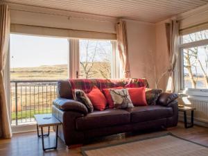 a couch in a living room with a large window at Villa Solas by Interhome in Kensaleyre