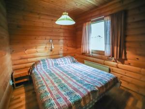 ein Schlafzimmer mit einem Bett in einer Blockhütte in der Unterkunft Holiday Home Pihatupa 2 by Interhome in Kuusamo