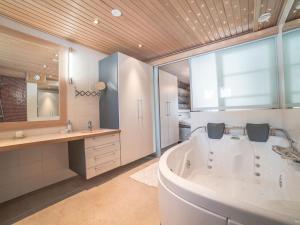 baño grande con bañera y lavamanos en Holiday Home Levin kreivi by Interhome, en Sirkka