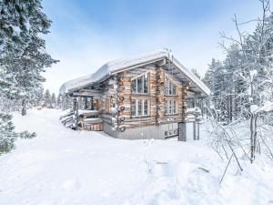 una cabaña de madera en el bosque en la nieve en Holiday Home Levin kreivi by Interhome, en Sirkka