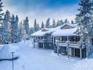 a log cabin in the snow with snow covered trees at Holiday Home Levin kreivi by Interhome in Sirkka
