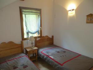 two beds in a small room with a window at Chaillol Le Vieux in Chaillol