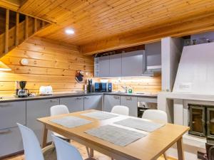 a kitchen with a wooden ceiling and a table and chairs at Holiday Home Saukonpiilo 2 by Interhome in Pyhätunturi