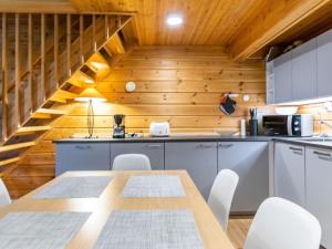 a kitchen with a table and chairs and wooden walls at Holiday Home Saukonpiilo 2 by Interhome in Pyhätunturi
