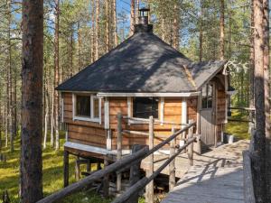 a log cabin in the woods with a wooden bridge at Holiday Home Nuovo casa a by Interhome in Sirkka