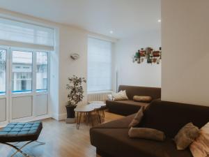 ein Wohnzimmer mit Sofa und Tisch in der Unterkunft Holiday Home Historical and spacious Villa Anaïs by Interhome in Blankenberge