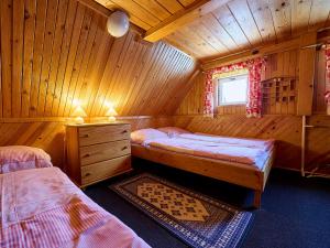 a bedroom with two beds in a wooden cabin at Holiday Home Paseky nad Jizerou by Interhome in Paseky nad Jizerou