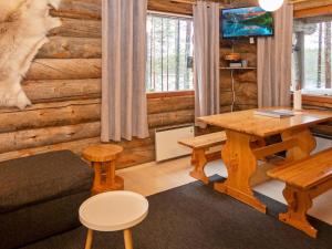 ein Wohnzimmer mit Tisch und Couch in der Unterkunft Holiday Home Hakojärven kelomajat 2 by Interhome in Ruka