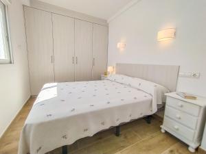 een witte slaapkamer met een bed en een ladekast bij Apartment Suecia by Interhome in Benidorm