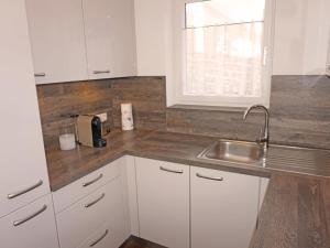 a kitchen with white cabinets and a sink at Apartment FeWo Anna by Interhome in Fliess