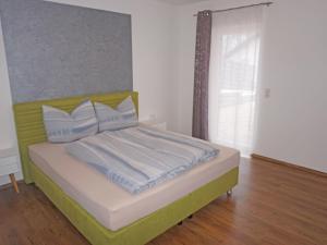 a bedroom with a green and white bed with a window at Apartment FeWo Anna by Interhome in Fliess