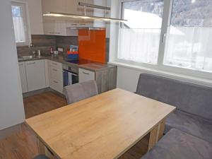 a kitchen with a wooden table and two chairs at Apartment FeWo Anna by Interhome in Fliess +39 photos