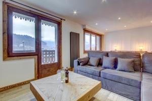 a living room with a couch and a table at Ruisseau One Apartment -Snow and Trek Montriond in Montriond
