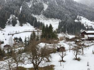 a snow covered mountain with houses and trees at Holiday Home Stark by Interhome in Kappl