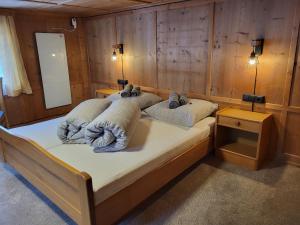 a large bed in a room with wooden walls at Holiday Home Stark by Interhome in Kappl