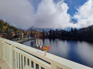 a balcony with a view of a lake with wine glasses at Apartment Alpes et Lac 40 by Interhome in Champex