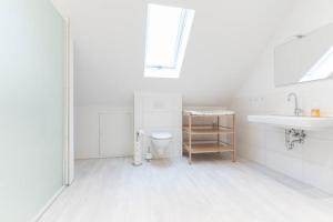 a white bathroom with a sink and a toilet at Ferienwohnung 140 qm OstfrieslandNordsee für 1-6 Personen - Südbrookmerland in Südbrookmerland