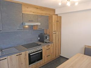 a kitchen with wooden cabinets and a stove top oven at Apartment Apart Handle by Interhome in Alterzoll