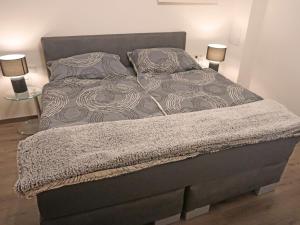a bed in a bedroom with two lamps on tables at Apartment Apart Handle by Interhome in Alterzoll