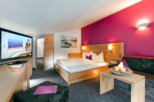 a hotel room with a bed and a flat screen tv at Hotel Gabriela INKLUSIVE SUPER SOMMER CARD in Serfaus