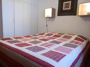 a bed in a room with a quilt on it at Apartment Cyre by Interhome in Sainte-Croix