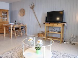 a living room with a tv and a glass table at Apartment Cyre by Interhome in Sainte-Croix