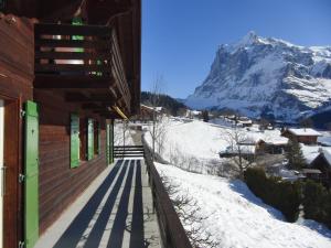 a building with a snow covered mountain in the background at Chalet Chalet Pitschun by Interhome in Grindelwald