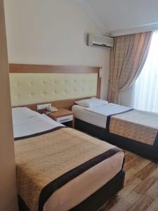 a hotel room with two beds and a window at HOTEL MİTOS in Alanya